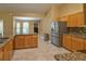 Modern kitchen with granite countertops, stainless steel refrigerator, and light wood cabinets at 15305 Shady Ln, Tavares, FL 32778