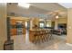 Open kitchen with granite island, stainless appliances, seating, and sightlines to the living room at 15305 Shady Ln, Tavares, FL 32778