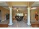 Spacious living room featuring tile floors, large columns, and comfortable leather furniture at 15305 Shady Ln, Tavares, FL 32778