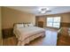 Bright main bedroom with wood flooring and a ceiling fan, offering a cozy and inviting space at 15305 Shady Ln, Tavares, FL 32778