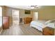 Spacious main bedroom featuring wood floors, a ceiling fan, and a walk-in closet for ample storage at 15305 Shady Ln, Tavares, FL 32778