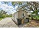 Exterior view of a small outbuilding with a roll-up door and a concrete driveway at 15305 Shady Ln, Tavares, FL 32778