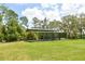 Exterior view of the parking structure surrounded by lush green grass and mature trees at 15305 Shady Ln, Tavares, FL 32778