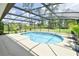 Inviting screened-in pool area with lush landscaping and ample deck space at 15305 Shady Ln, Tavares, FL 32778