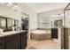 Bathroom with corner soaking tub, double vanity, and private closet access at 15465 Heron Hideaway Cir, Winter Garden, FL 34787