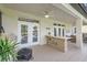 Covered patio with an outdoor kitchen, ceiling fans, and views of the pool and backyard at 15465 Heron Hideaway Cir, Winter Garden, FL 34787