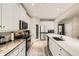 Well-equipped kitchen with white cabinets, stainless steel appliances, a large island, and elegant countertops at 15465 Heron Hideaway Cir, Winter Garden, FL 34787