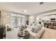 Open living room with white sofa, modern flooring, and view of kitchen area at 15465 Heron Hideaway Cir, Winter Garden, FL 34787