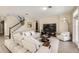 Bright living room boasts hardwood floors, staircase, and comfortable white furniture at 15465 Heron Hideaway Cir, Winter Garden, FL 34787
