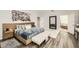 Spacious bedroom with wood floors, ensuite bath, and accent wall art at 15465 Heron Hideaway Cir, Winter Garden, FL 34787