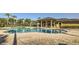 Community pool with palm trees, covered tables, and lounge chairs for residents to enjoy at 15465 Heron Hideaway Cir, Winter Garden, FL 34787