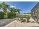 Beautifully landscaped backyard with a serene water view, palm trees and brick patio at 15465 Heron Hideaway Cir, Winter Garden, FL 34787