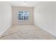 Bright bedroom featuring a neutral color scheme, plush carpeting, and a window with natural light at 15485 Sandfield Loop, Winter Garden, FL 34787