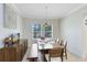 Bright dining room with neutral tones, a modern light fixture, and large windows overlooking the outdoor scenery at 15485 Sandfield Loop, Winter Garden, FL 34787
