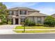 Charming two-story home with a well-manicured lawn, beautiful landscaping, and a paved driveway at 15485 Sandfield Loop, Winter Garden, FL 34787