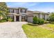 Two-story home with brick driveway and shutters; two-car garage and landscaping at 15485 Sandfield Loop, Winter Garden, FL 34787