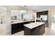 Modern kitchen with sleek black cabinetry, stainless steel appliances, and a large island at 15485 Sandfield Loop, Winter Garden, FL 34787