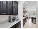 Modern kitchen with stainless steel appliances, sleek black cabinets, and quartz countertops at 15485 Sandfield Loop, Winter Garden, FL 34787