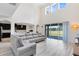 Open-concept living room featuring soaring ceilings, modern lighting, and a seamless connection to the kitchen at 15485 Sandfield Loop, Winter Garden, FL 34787