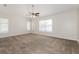 Spacious bedroom with neutral carpet, ceiling fan, and multiple windows for ample natural light at 1653 Turtle Rock Dr, Lakeland, FL 33803