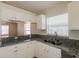 Well-lit kitchen with granite countertops, stainless steel sink and white cabinetry at 1653 Turtle Rock Dr, Lakeland, FL 33803