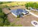 A beautiful aerial view displays a home with a screened porch, lush garden, and extended driveway at 18920 Overton St, Orlando, FL 32833
