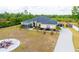An aerial view of a home with a screened porch, garden, pergola and circular patio with fire pit at 18920 Overton St, Orlando, FL 32833