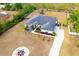 Overhead view of large home with big yard, a long driveway, and a circular patio with a fire pit at 18920 Overton St, Orlando, FL 32833