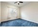 Neutral bedroom featuring blue carpet, ceiling fan, and natural light from the window at 18920 Overton St, Orlando, FL 32833
