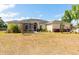 Wide view of the yard with beige home, screened lanai, and meticulous landscaping at 18920 Overton St, Orlando, FL 32833