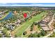 An aerial view of a golf course community featuring well-maintained homes, a golf course, and a lake at 196 Torino Ln, Kissimmee, FL 34759