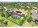 Aerial view of a home with solar panels, a screened-in pool, and lush landscaping at 196 Torino Ln, Kissimmee, FL 34759