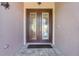 Elegant double front doors with decorative glass panels, set in a stucco exterior, offering a grand entrance to the home at 196 Torino Ln, Kissimmee, FL 34759