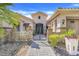 Close up of the front of a house featuring a metal gate, stone accents, and well manicured landscaping at 196 Torino Ln, Kissimmee, FL 34759