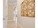 Hallway featuring neutral paint, closet, and a decorative quilt on the wall leading to other rooms at 196 Torino Ln, Kissimmee, FL 34759