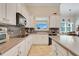 Well-lit kitchen with white cabinets, tile backsplash, and modern appliances, creating a clean and functional space for cooking at 196 Torino Ln, Kissimmee, FL 34759