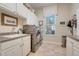 Laundry room features white cabinets, a sink, and modern stainless steel appliances at 196 Torino Ln, Kissimmee, FL 34759