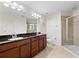 Bathroom featuring double sinks, granite countertop, and a glass-enclosed shower, offering a modern design at 2112 Rookery Ln, Sanford, FL 32773