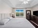 Bright main bedroom featuring a tray ceiling, a large window overlooking the lake, and ample natural light at 2112 Rookery Ln, Sanford, FL 32773