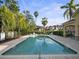 Community pool with lounge chairs surrounded by greenery and palm trees at 2112 Rookery Ln, Sanford, FL 32773