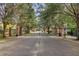 Community entrance gate featuring black iron details, brick pillars, and mature trees along the roadway at 2112 Rookery Ln, Sanford, FL 32773