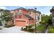 Inviting two-story townhome with a two-car garage and colorful peach and beige exterior at 2112 Rookery Ln, Sanford, FL 32773