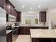 Stylish kitchen featuring granite countertops, stainless steel appliances, and dark wood cabinetry at 2112 Rookery Ln, Sanford, FL 32773