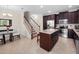 Elegant kitchen featuring a granite island, stainless steel appliances, and dark cabinets near dining area at 2112 Rookery Ln, Sanford, FL 32773