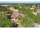 Aerial view of a landscaped home with dark roof nestled amongst mature trees at 2241 Lake Vilma Dr, Orlando, FL 32835