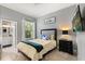 Cozy bedroom featuring a comfortable bed, side table, and an adjacent bathroom at 2241 Lake Vilma Dr, Orlando, FL 32835