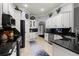 Spacious kitchen with white cabinets, sleek black countertops, and stainless steel appliances at 2241 Lake Vilma Dr, Orlando, FL 32835