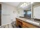 Bathroom showcasing a granite countertop vanity, wood cabinets, tile floors, and a walk-in shower at 2302 Edmonton Ct, Clermont, FL 34711