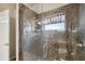 Modern shower with glass doors and granite tile surround plus convenient grab bars and handheld shower head at 2302 Edmonton Ct, Clermont, FL 34711