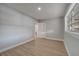 A bedroom with light gray walls, wood-look flooring and a door leading to the bathroom at 2303 Bonneville Dr, Orlando, FL 32826